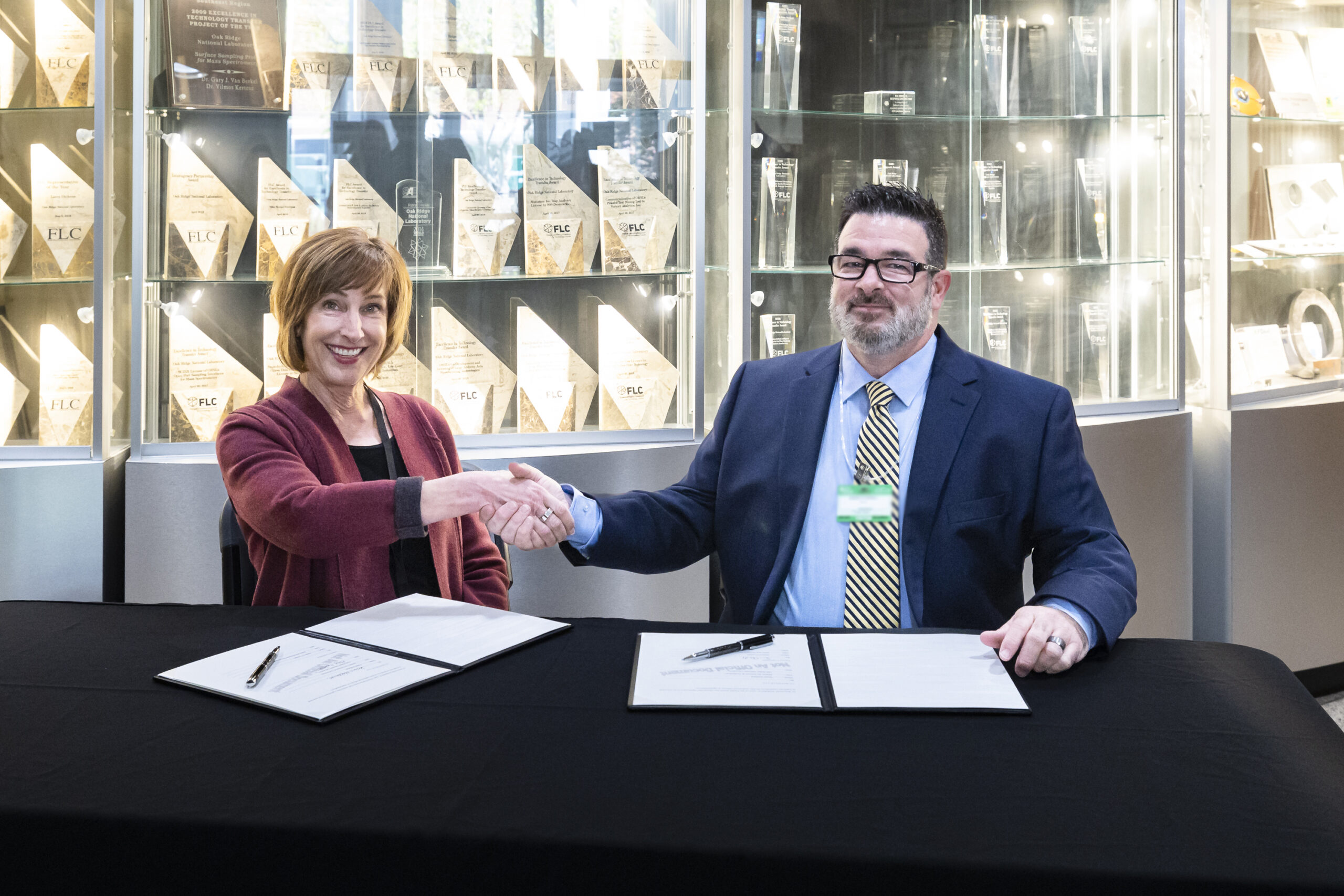 Susan Hubbard, ORNL deputy for science and technology, and Jason O’Connell, sales and business development manager for Teletrix, shake hands after signing a licensing agreement