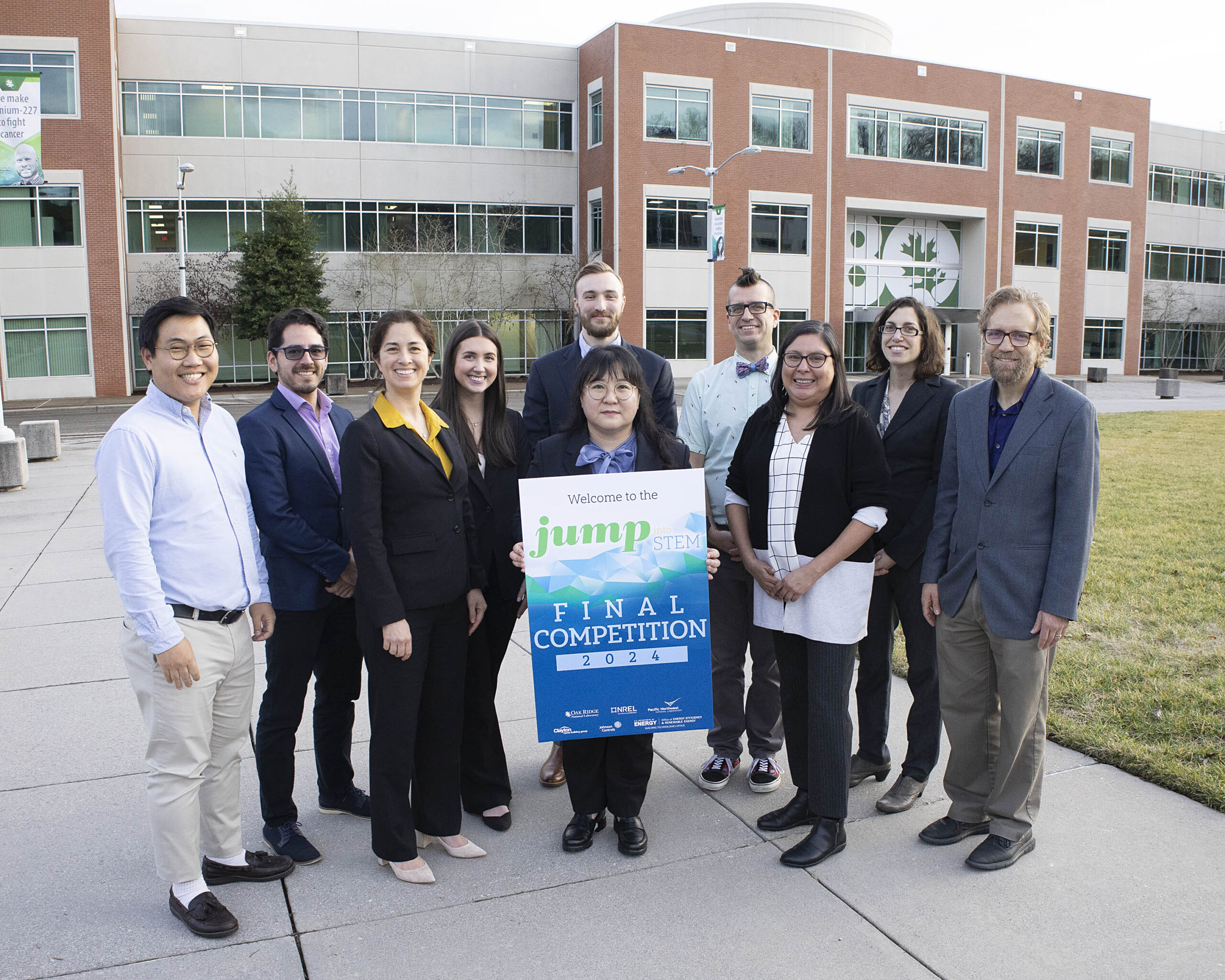 10 members of JUMP into STEM leadership are standing on the ORNL quad posting with the poster