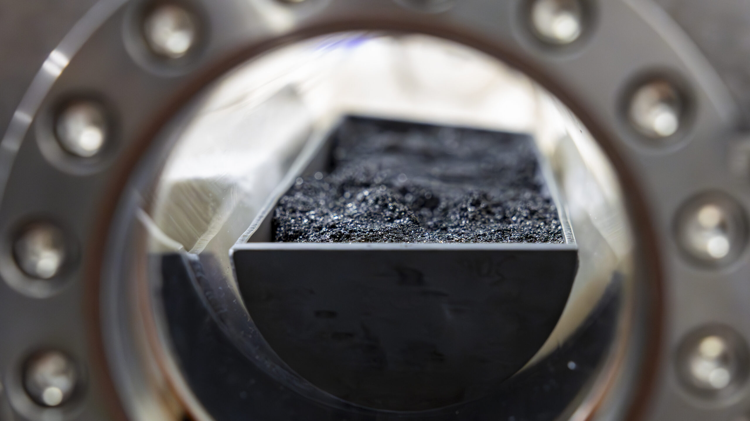Coal granules are in a long circular tray and loaded into a reactor