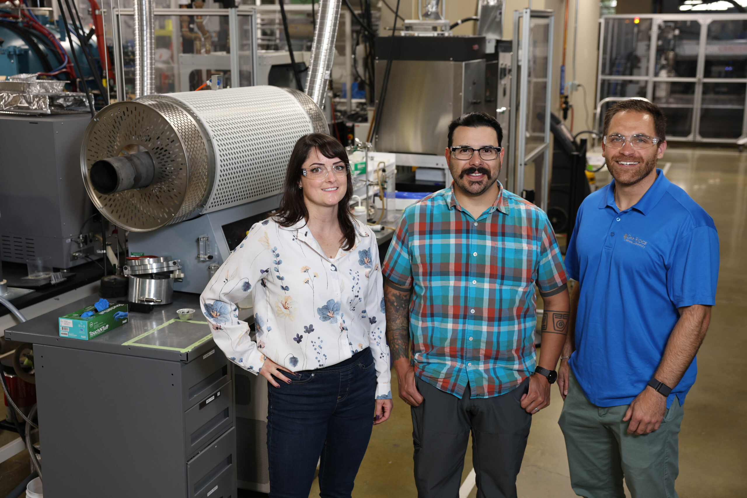From left, Amy Elliott, Trevor Aguirre and Corson Cramer stand next to a tube furnace, which was used for heat-treating the materials used in this study. Credit: Amy Smotherman Burgess/ORNL, U.S. Dept. of Energy