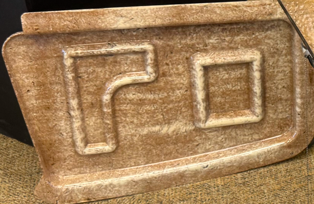 Image of an automotive interior door panel prototype made using natural fibers, giving it a brown hue.