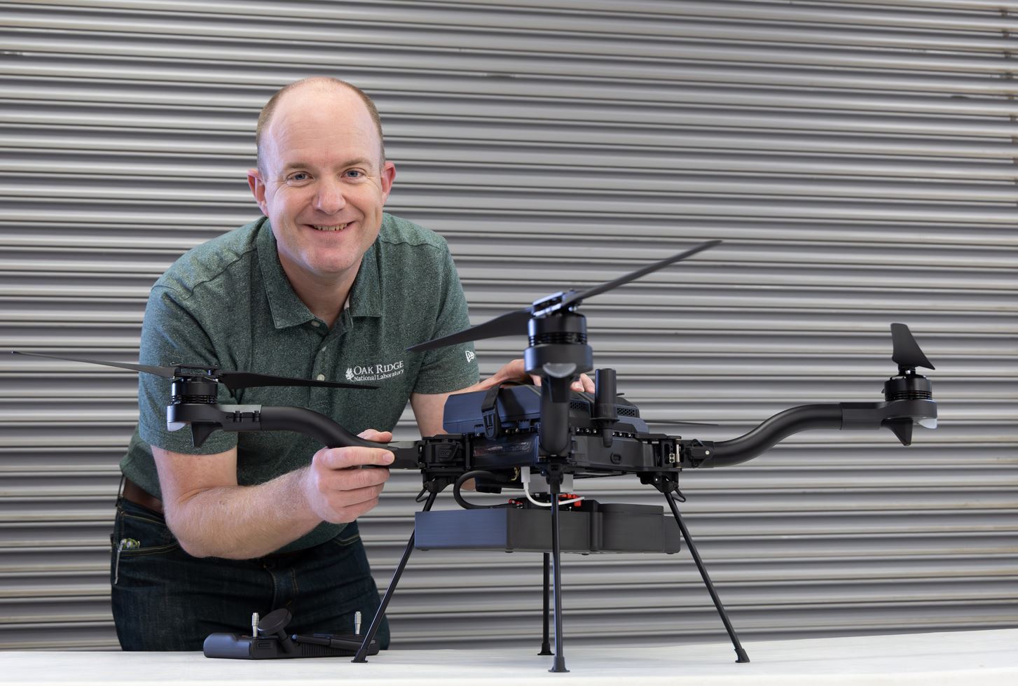 ORNL researcher is posing beside a drone