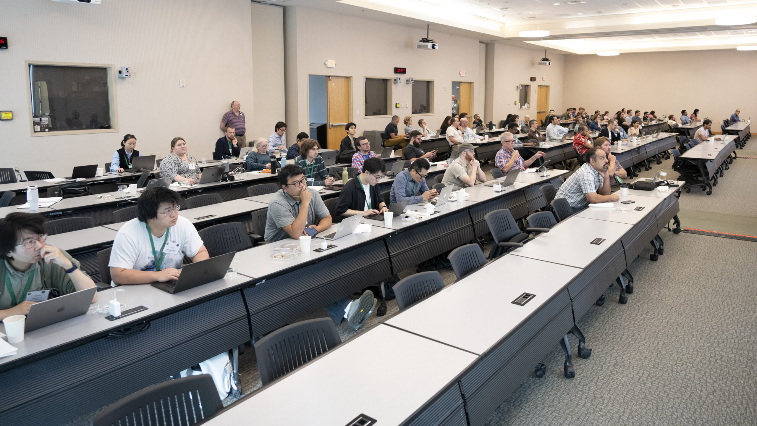 Large group of attendees are in a conference room for workshop presentation
