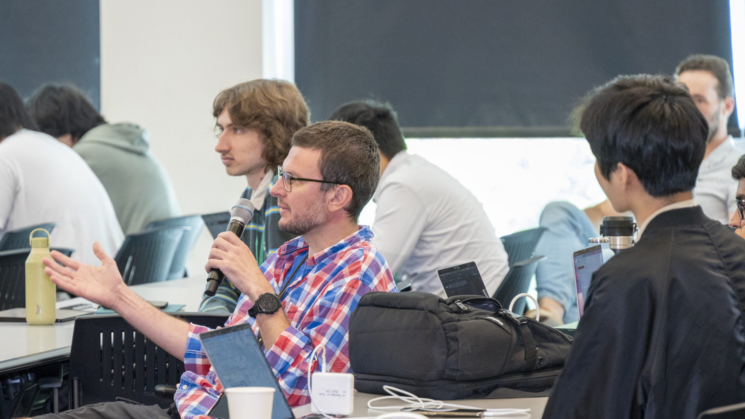 Participants from the workshop are sitting at desks having roundtable discussions
