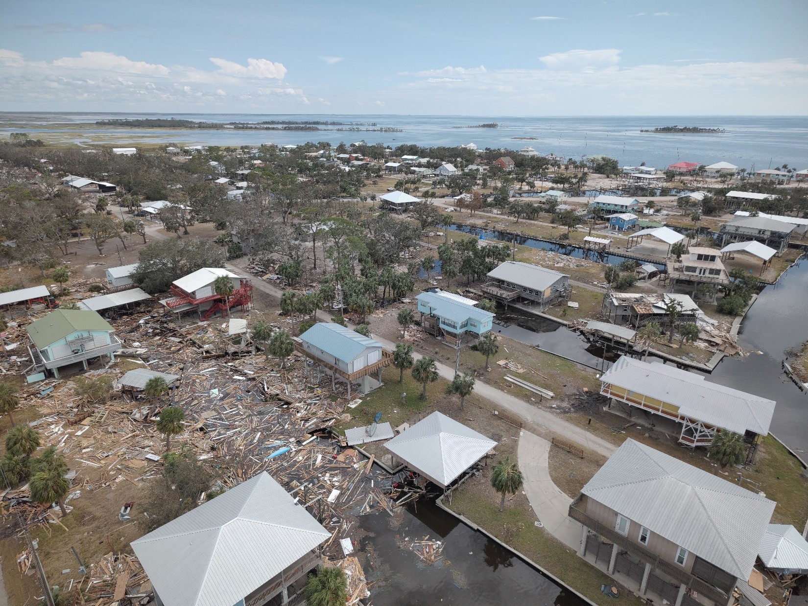 Images of damaged homes with debris on the ground