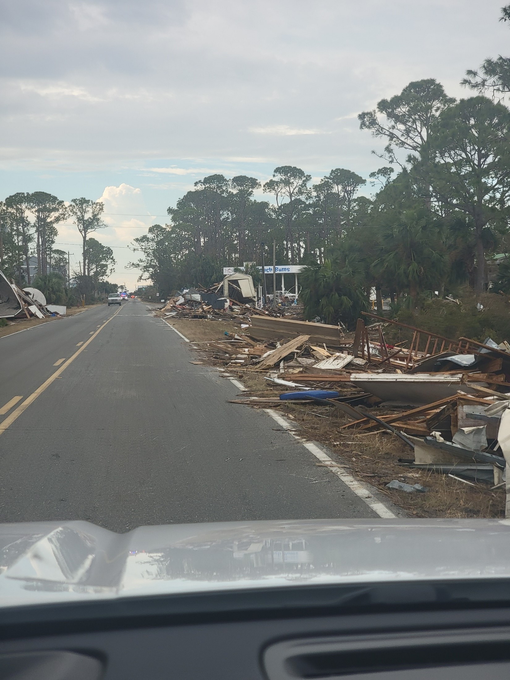 A front seat view of hurricane debris on the road from inside the car. 