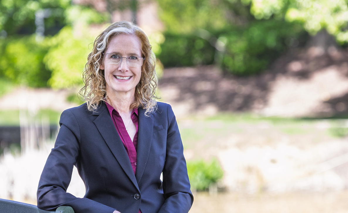Woman in a grey blazer poses outside for an professional photo