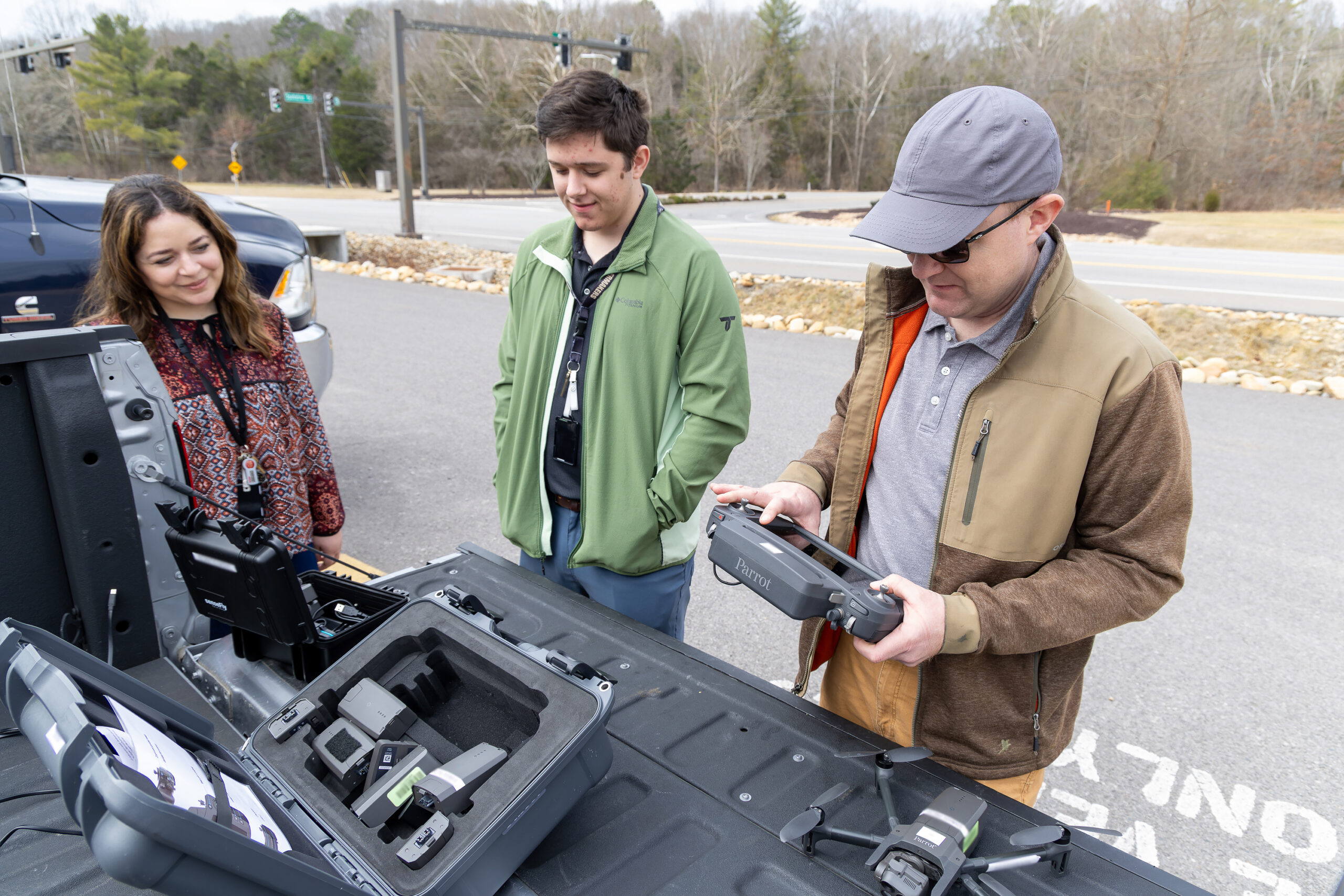 Jairus Hines (right) and Zack Ryan unpack a drone before takeoff for gathering images of passing cars and trucks, which Sally Ghanem (left) uses to train vehicle recognition software.
