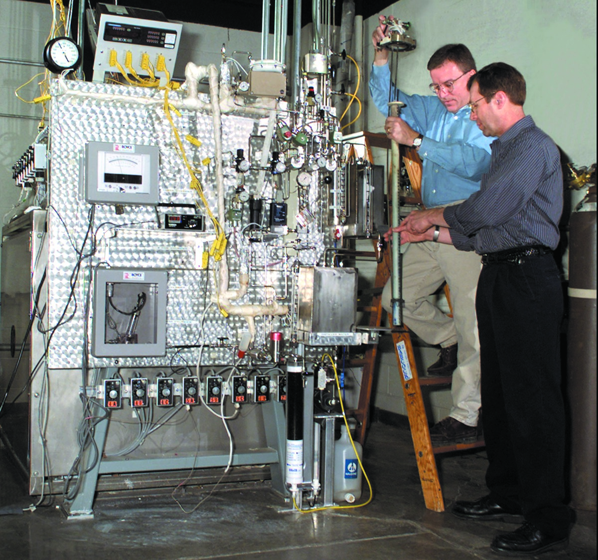 Two researchers examining data on computer monitors in a laboratory setting.