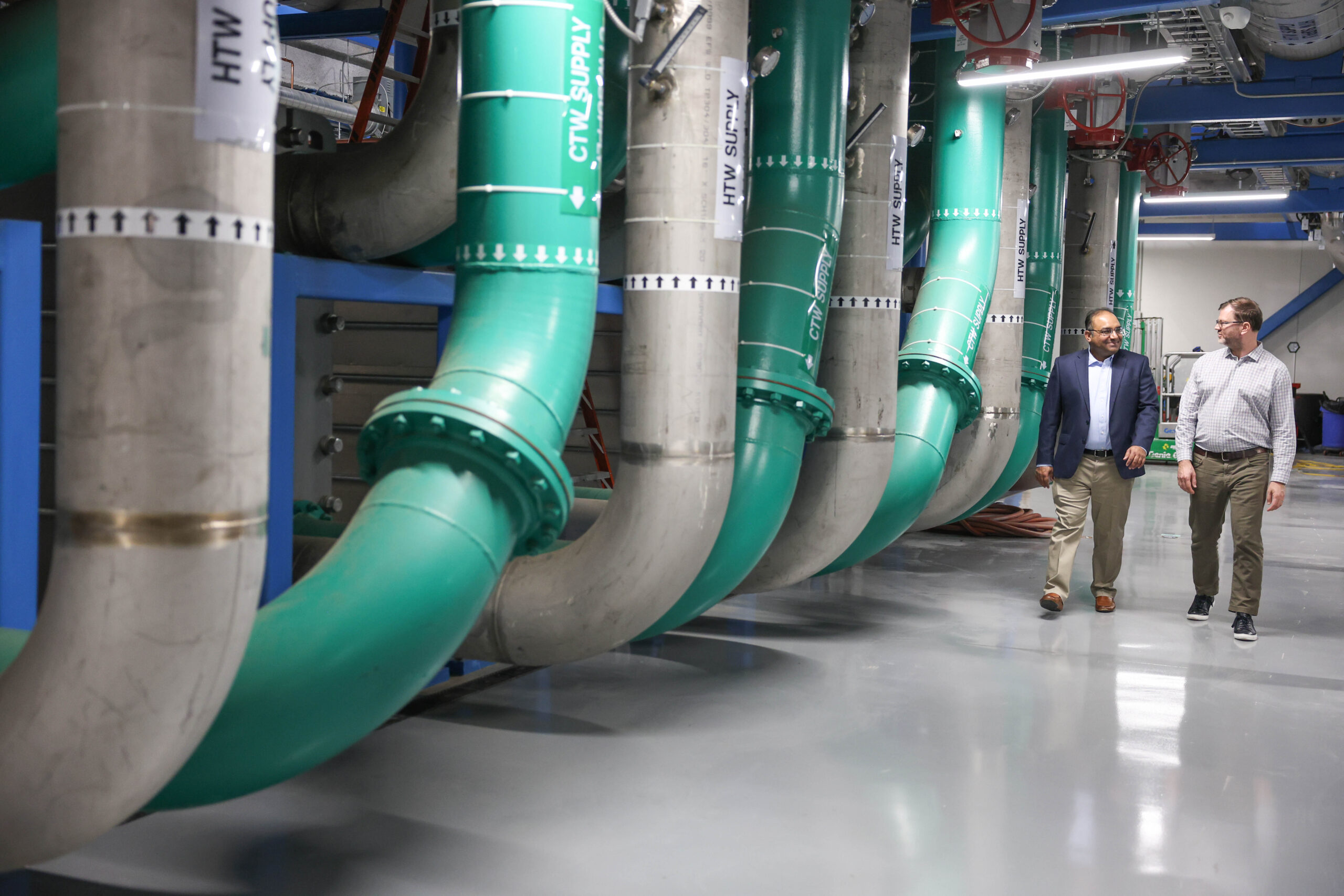 Kashif Nawaz, head of the Building Technologies Research Section, and Wes Brewer, senior research scientist in the National Center for Computational Sciences, walk through the energy plant that supports the Frontier data center.