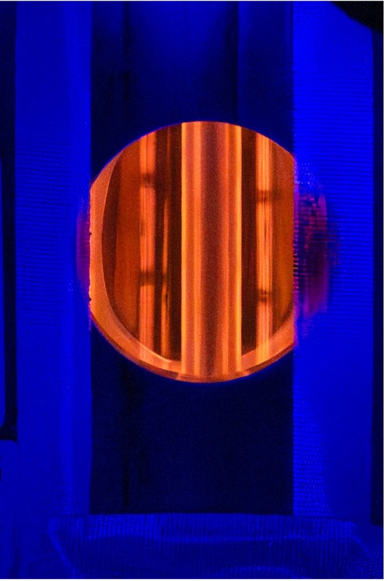 Glowing nuclear fuel cladding sample undergoing high-temperature testing.
