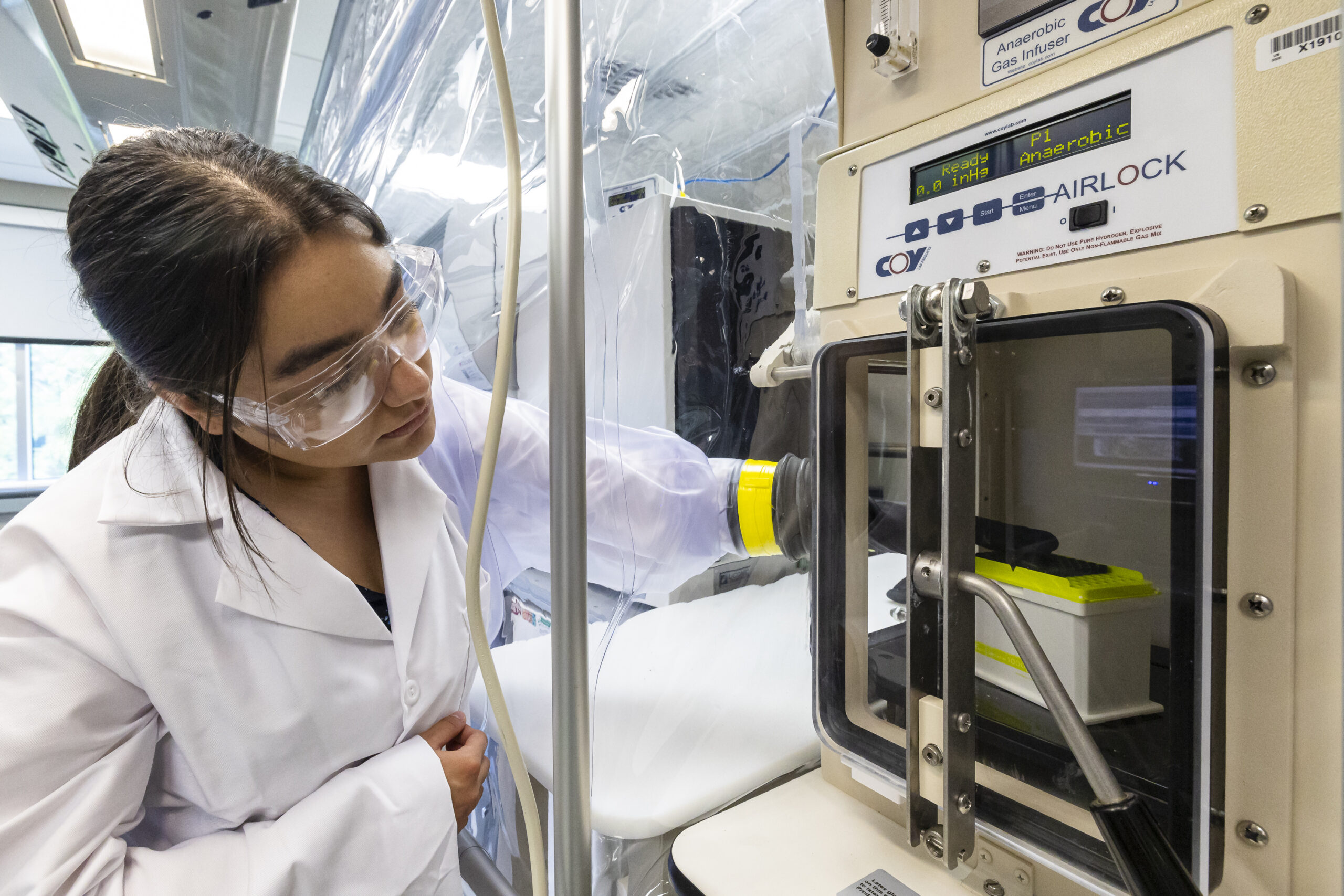 Andrea Garza Elizondo works with high-throughput microbial phenotyping equipment at ORNL