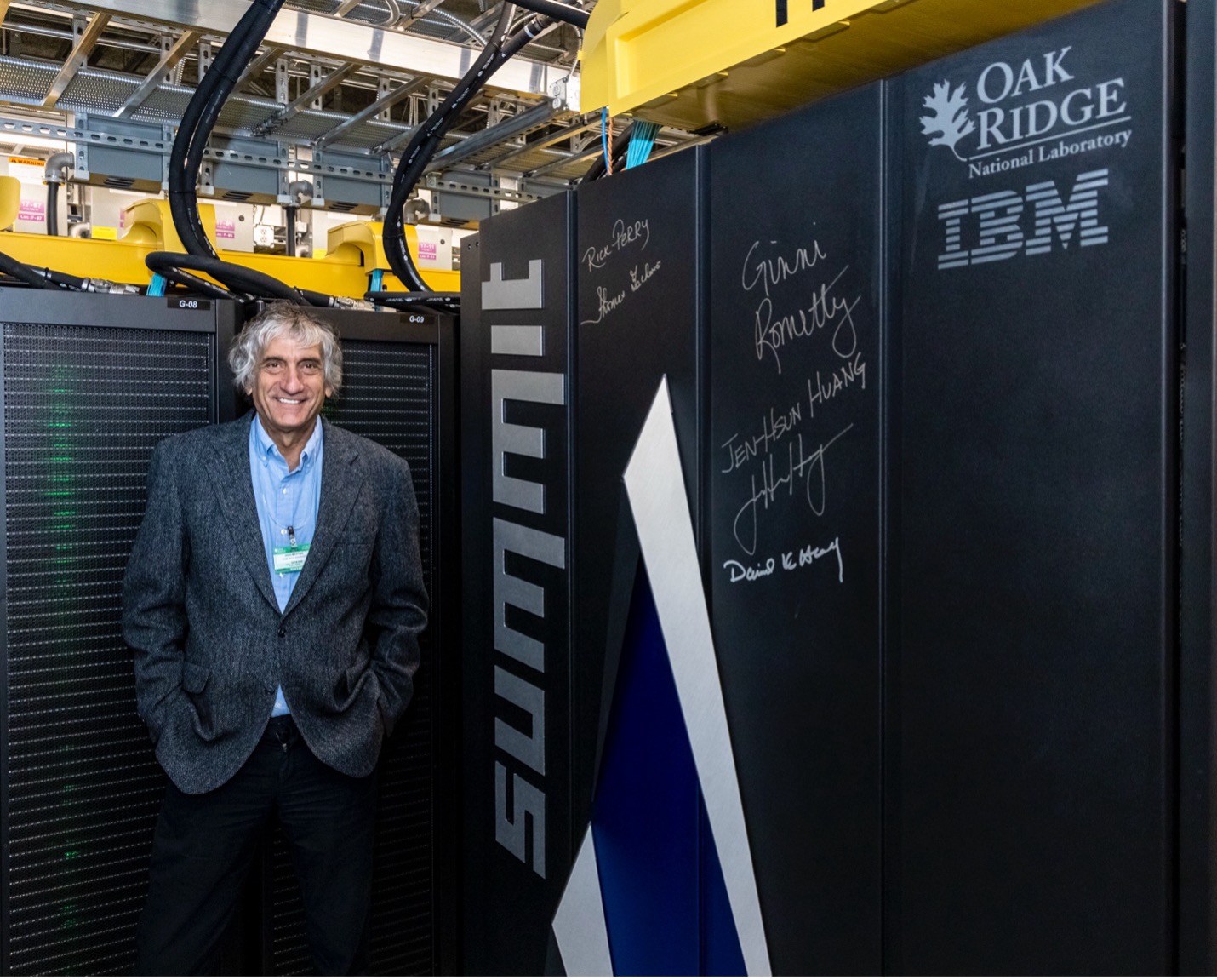 Man standing next to the IBM Summit supercomputer at ORNL