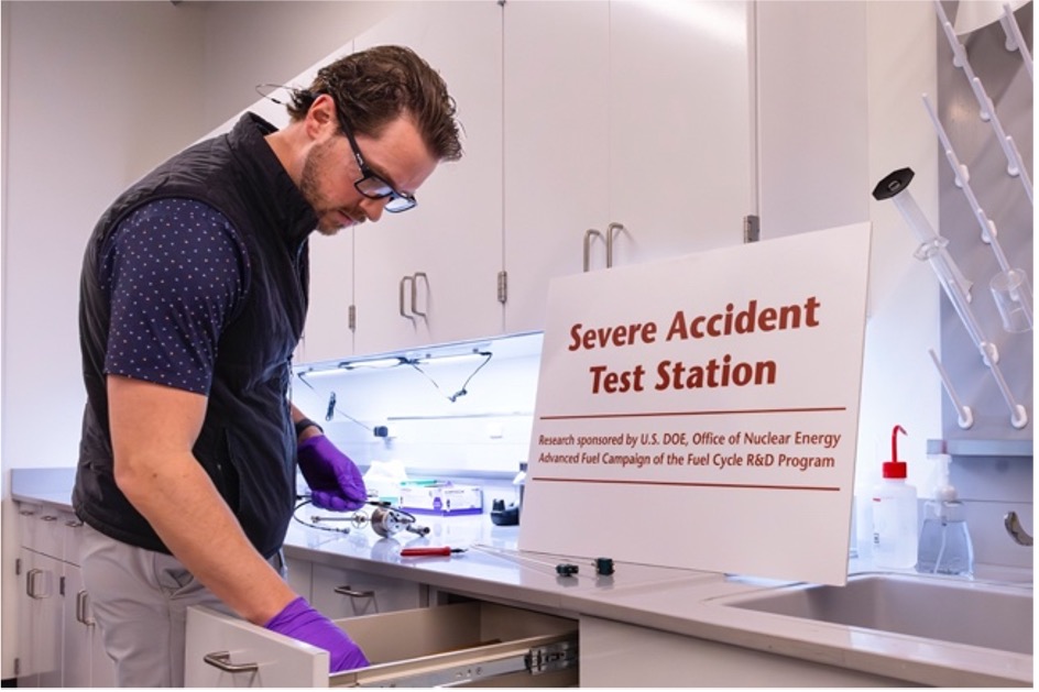 Researcher prepares equipment at ORNL’s Severe Accident Test Station in a laboratory.