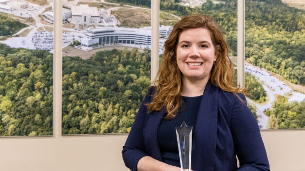 Cait Clarkson, an R&D associate staff member at Oak Ridge National Laboratory, holds the Young Professional Emerging Leader Award while posing for a portrait at ORNL.