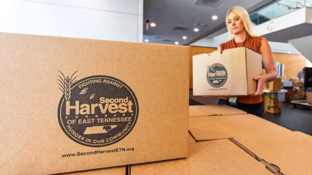 ORNL employees pack food for Second Harvest Food Bank during an ORNL Gives volunteer event in the lobby of Building 4100.