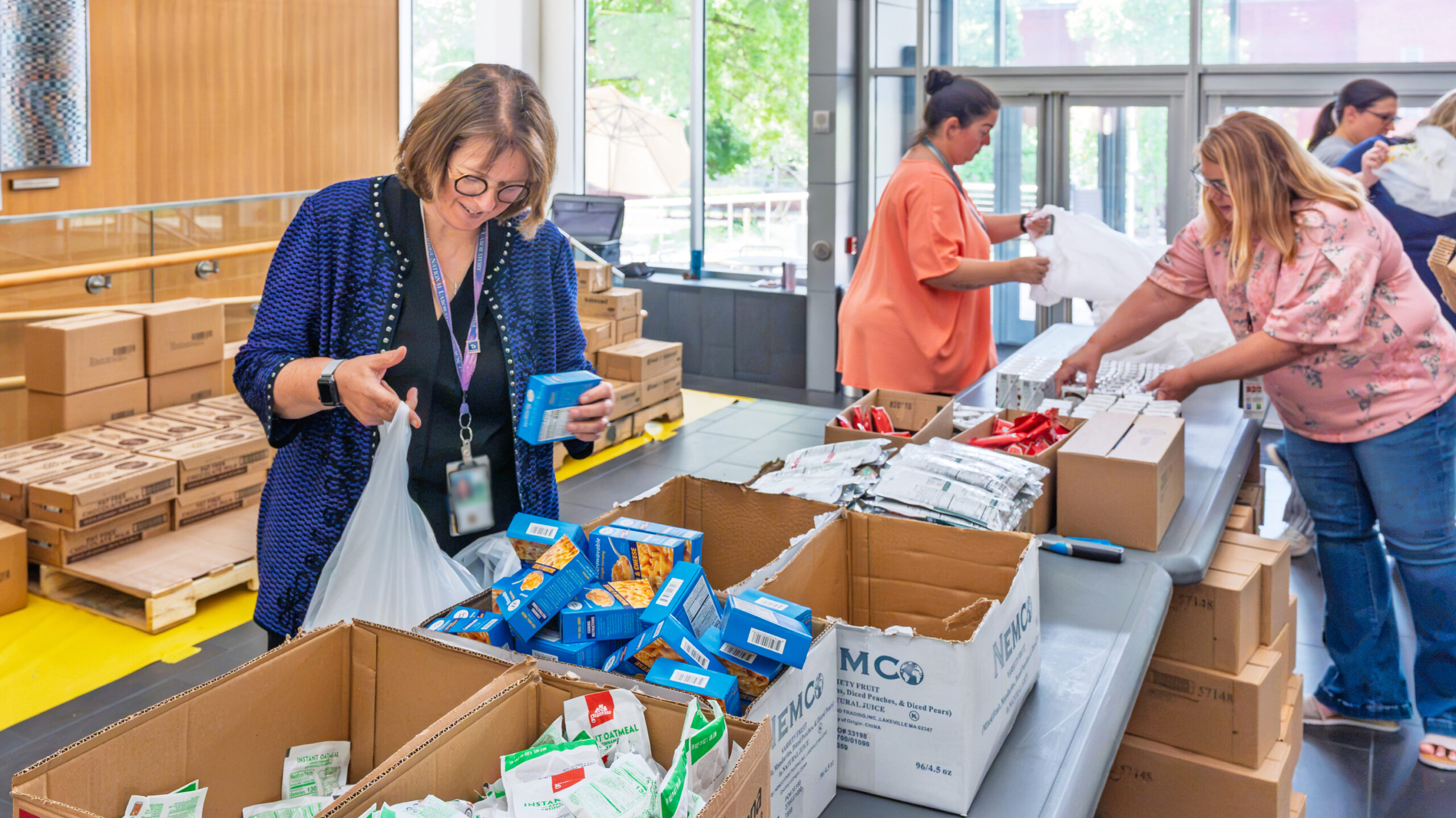 Volunteers pack food and supplies into bags at a community service event.