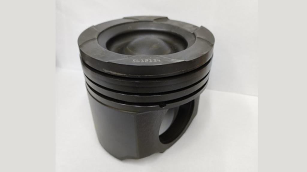 Black steel engine piston with multiple piston ring grooves and a recessed crown, shown on a white background.
