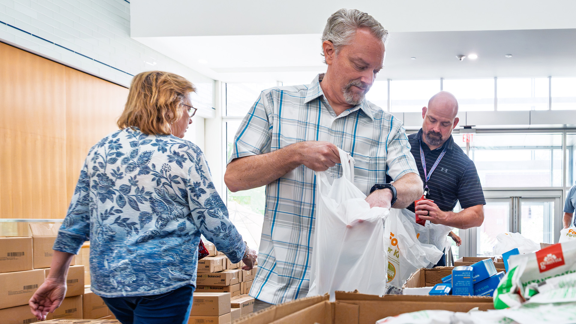 ORNL employees pack weekend food bags with shelf-stable groceries during a volunteer event supporting Second Harvest Food Bank of East Tennessee.