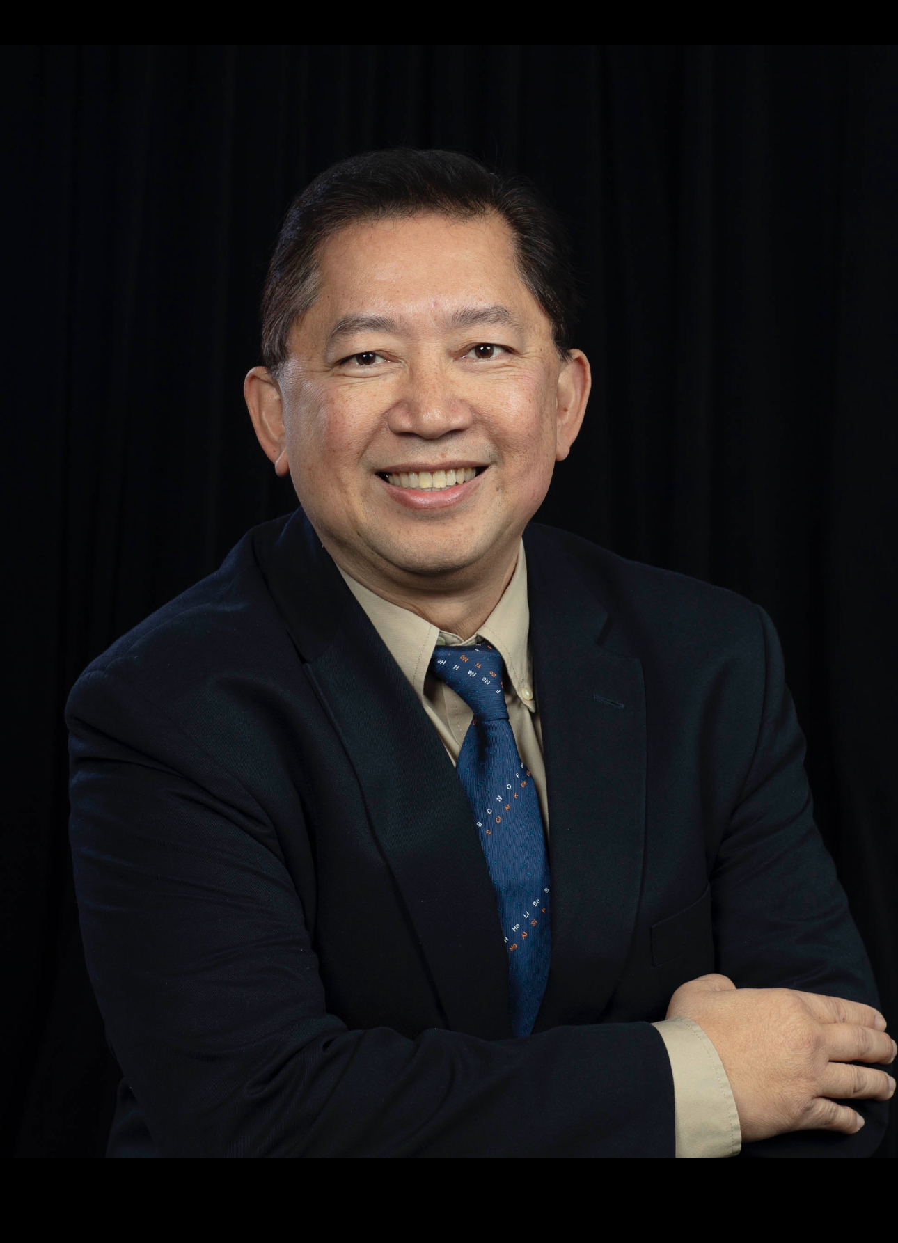 ORNL researcher Rigoberto Advincula poses for a portrait with a suit and tie