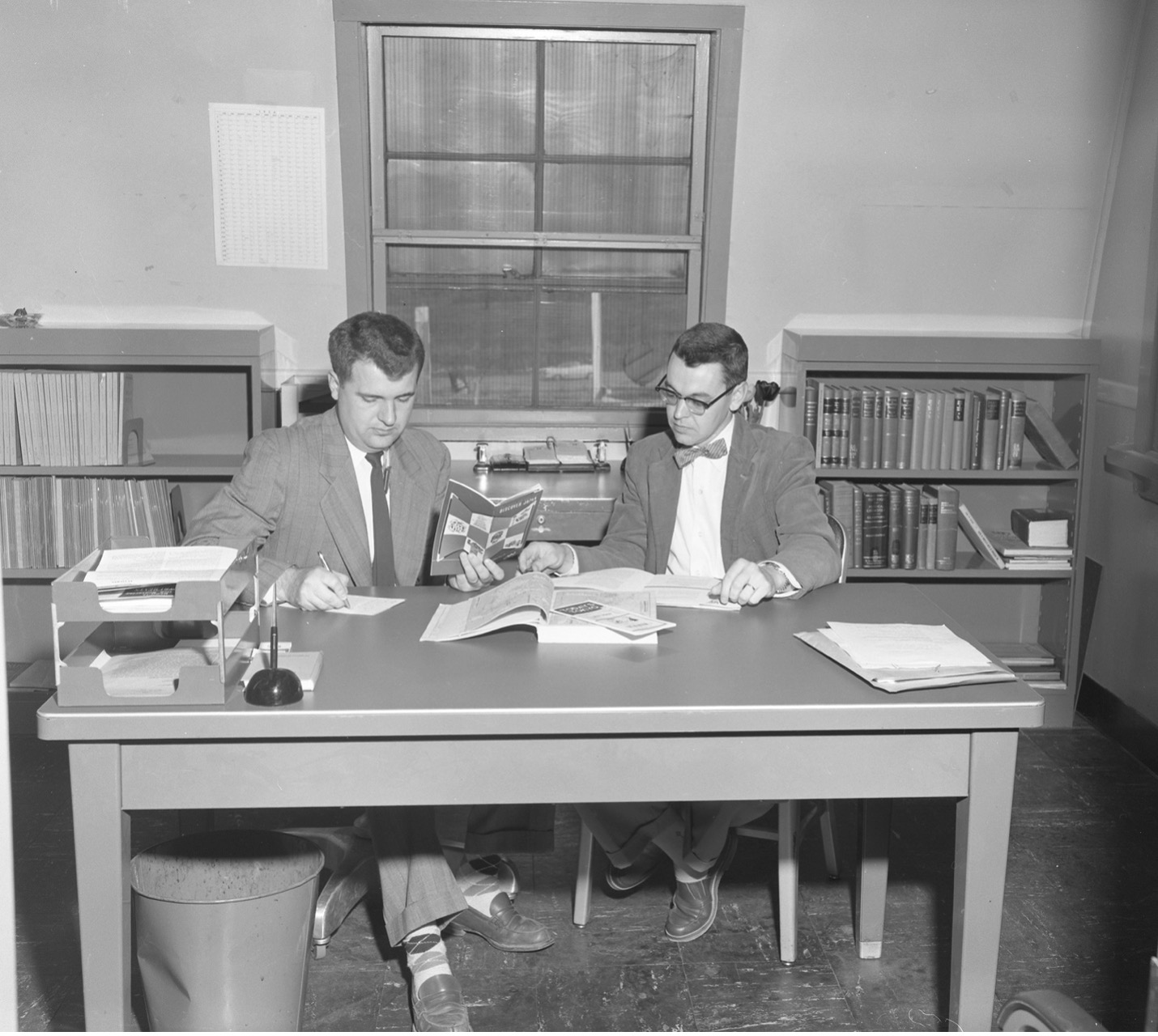 Hurst and Rufus Ritchie review documents together in an office.