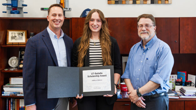 Stephen Streiffer presents the CCED Employee Student Award to Addison Malone while her father, Devin Malone, stands nearby during a ceremony at Oak Ridge National Laboratory.