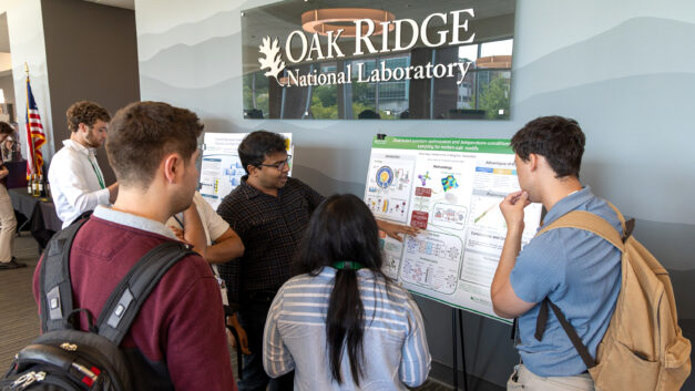 Manas Sajjan, Research Scientist in Quantum HPC Systems, discusses his research poster with conference attendees during the poster session at the 2026 Quantum Computing User Forum at Oak Ridge National Laboratory.