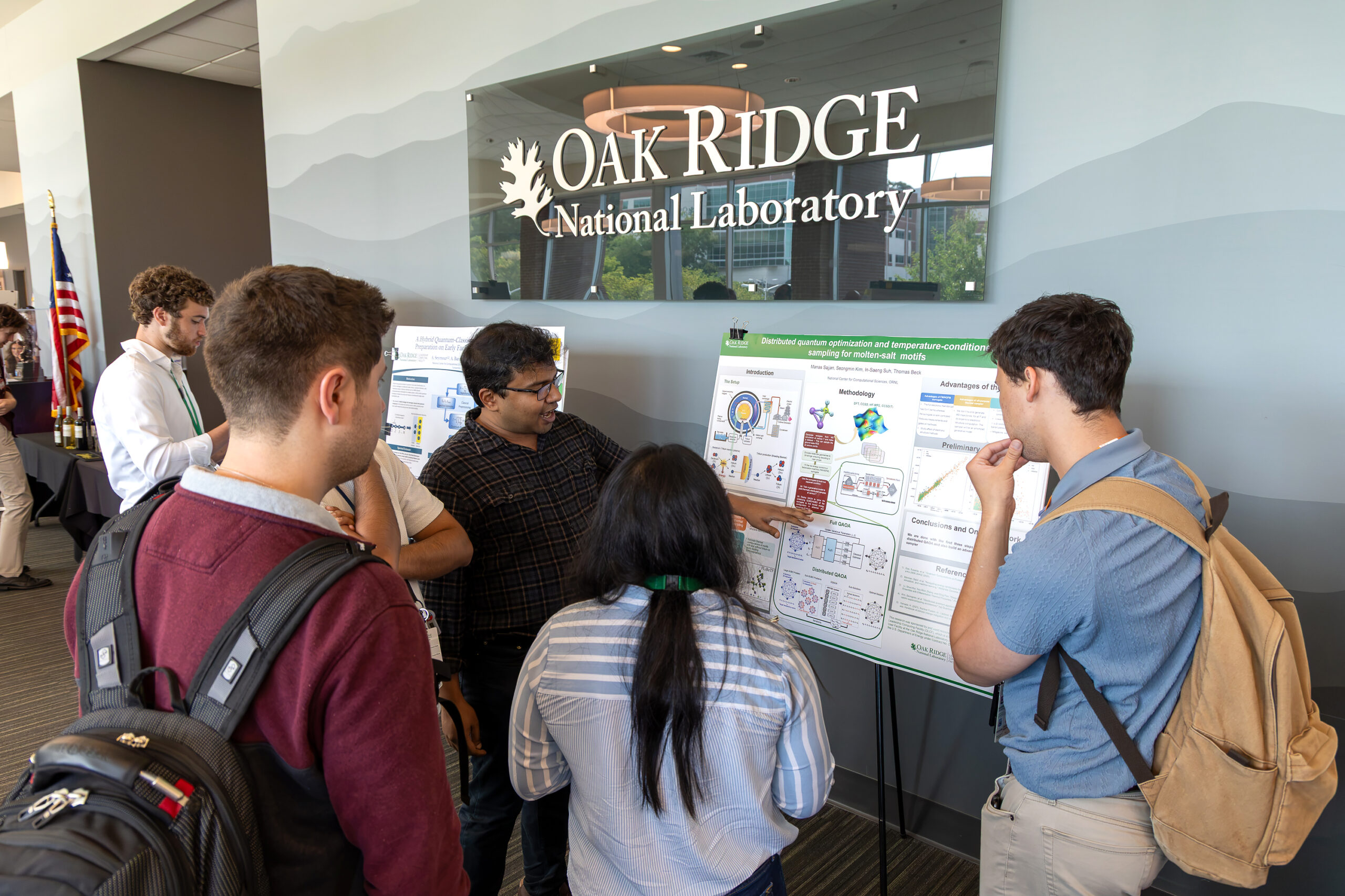 Attendees discuss quantum research during the QCUF poster session.