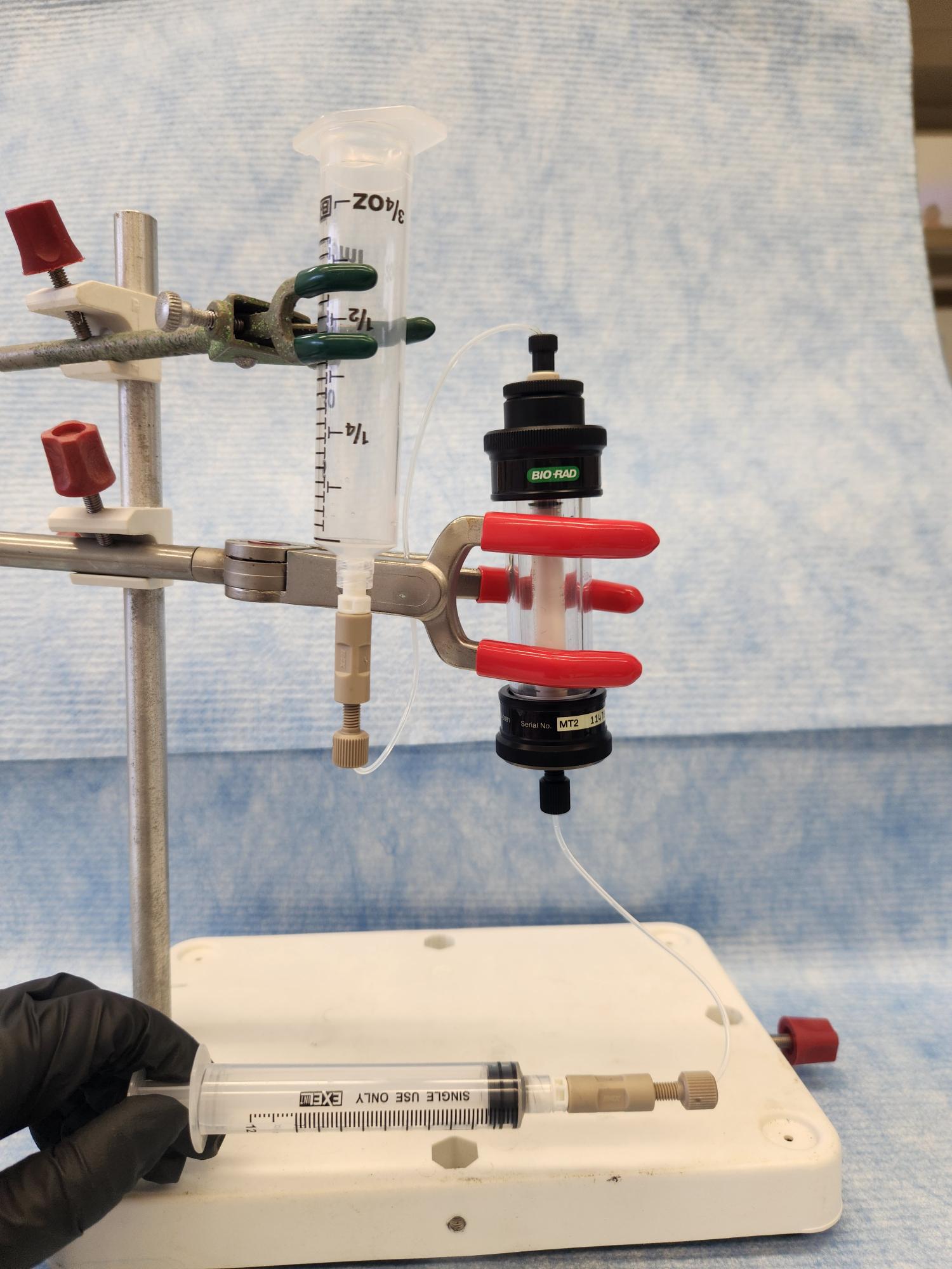 Laboratory setup with syringes, tubing, and a cylindrical generator column.