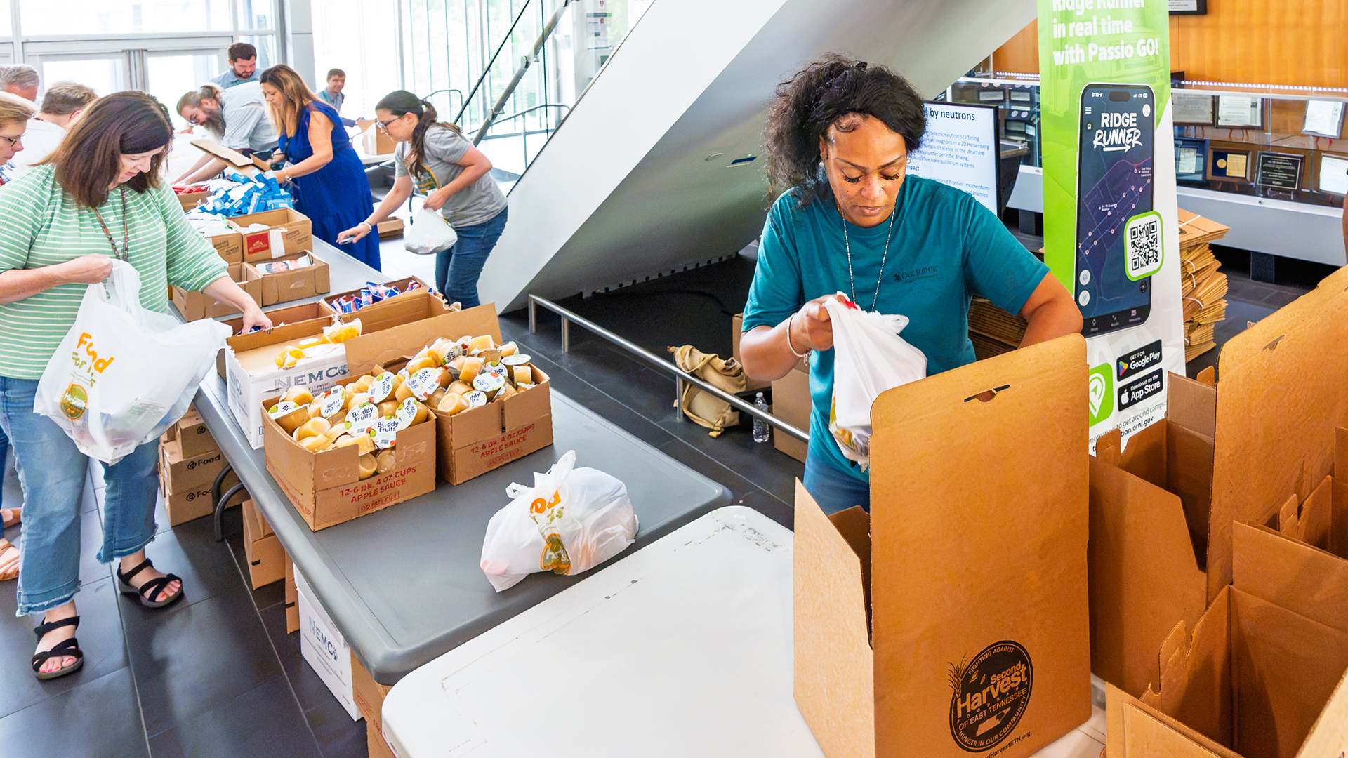 Volunteers pack food into bags and boxes for a community service project.